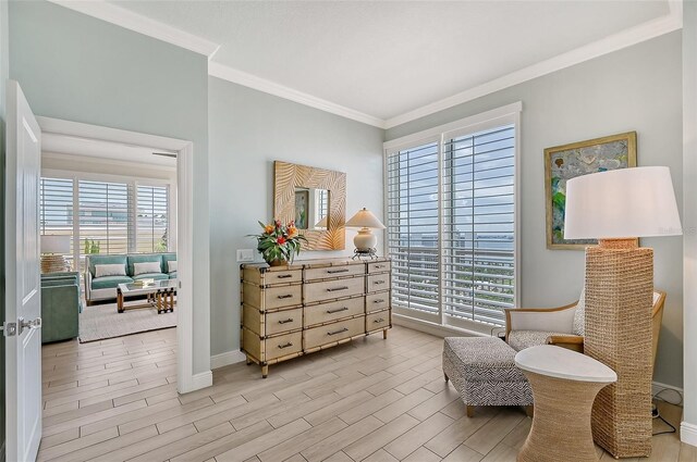 sitting room with light hardwood / wood-style floors and crown molding