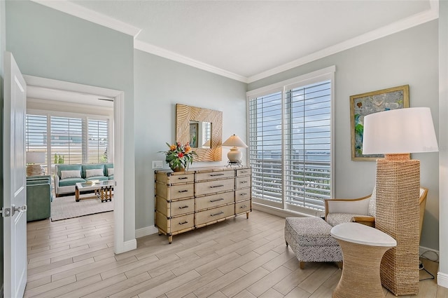 sitting room with ornamental molding and light wood-type flooring