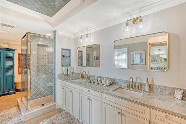 bathroom featuring an enclosed shower, crown molding, a raised ceiling, and vanity