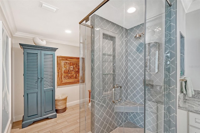 bathroom with wood-type flooring, crown molding, and an enclosed shower