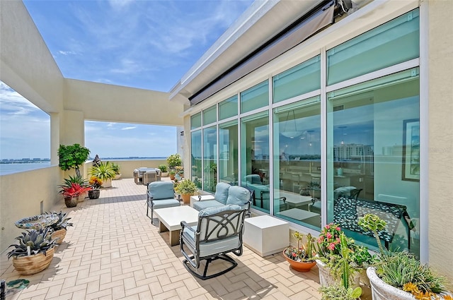 view of patio / terrace with a water view and an outdoor living space