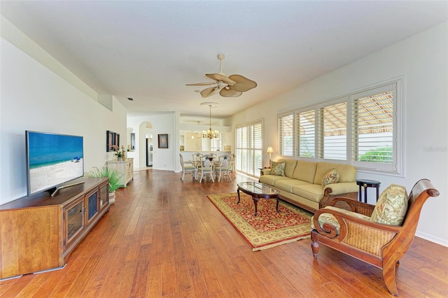 living room featuring hardwood / wood-style flooring and ceiling fan with notable chandelier