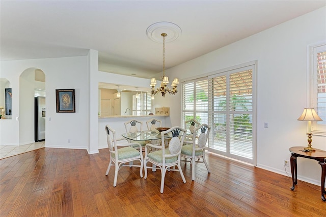 dining space featuring wood-type flooring and a chandelier