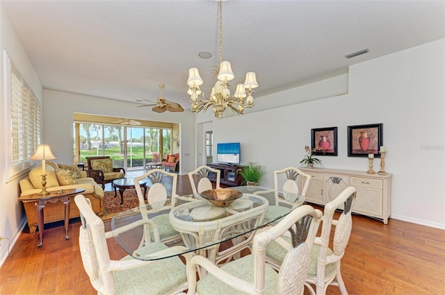 dining area featuring ceiling fan with notable chandelier and light hardwood / wood-style floors