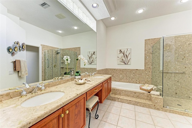 bathroom with tile patterned floors, plus walk in shower, a textured ceiling, and dual bowl vanity