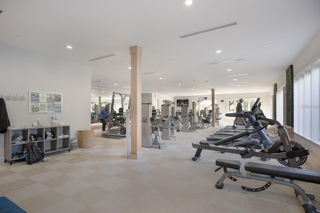 workout area featuring light tile patterned floors and decorative columns