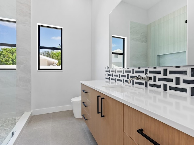 bathroom with decorative backsplash, vanity, tiled shower, and toilet