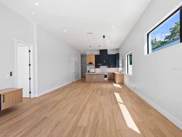 unfurnished living room with sink and hardwood / wood-style floors