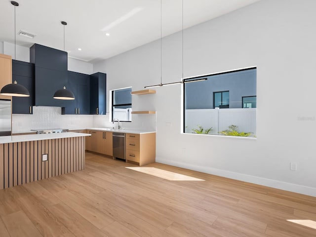 kitchen with appliances with stainless steel finishes, light hardwood / wood-style floors, and decorative light fixtures