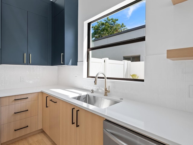 kitchen with light hardwood / wood-style floors, light brown cabinetry, sink, backsplash, and stainless steel dishwasher