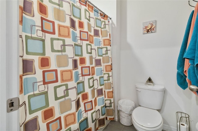 bathroom with toilet, curtained shower, and tile patterned flooring