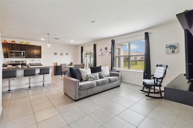 living room featuring a textured ceiling and light tile patterned flooring