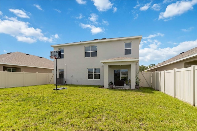 rear view of property with a lawn and central AC unit