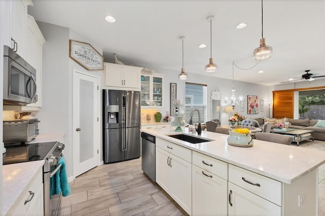 kitchen with white cabinetry, a center island with sink, and stainless steel appliances