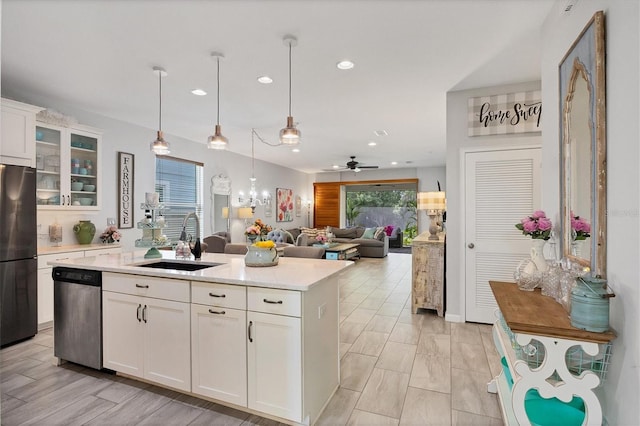 kitchen featuring white cabinetry, sink, stainless steel dishwasher, and fridge