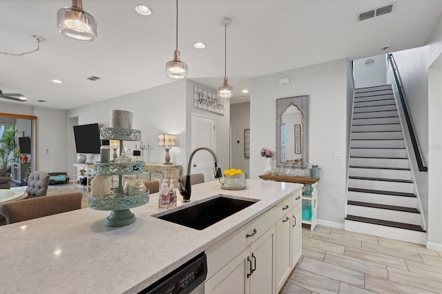 kitchen with hanging light fixtures, sink, ceiling fan, dishwasher, and white cabinets