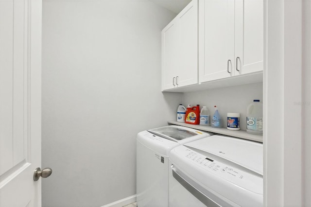 laundry room featuring washer and clothes dryer and cabinets