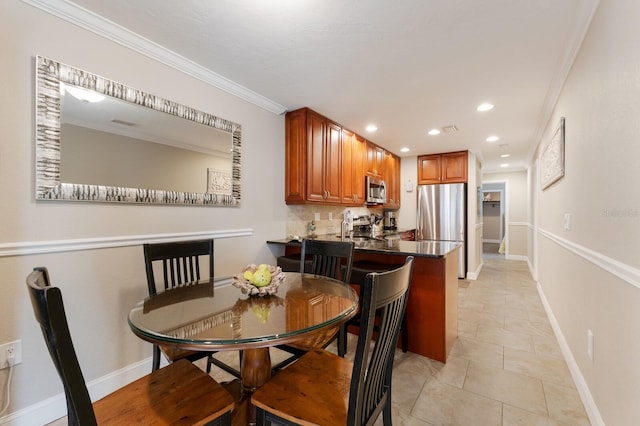 kitchen with kitchen peninsula, stainless steel appliances, light tile patterned floors, crown molding, and a breakfast bar area