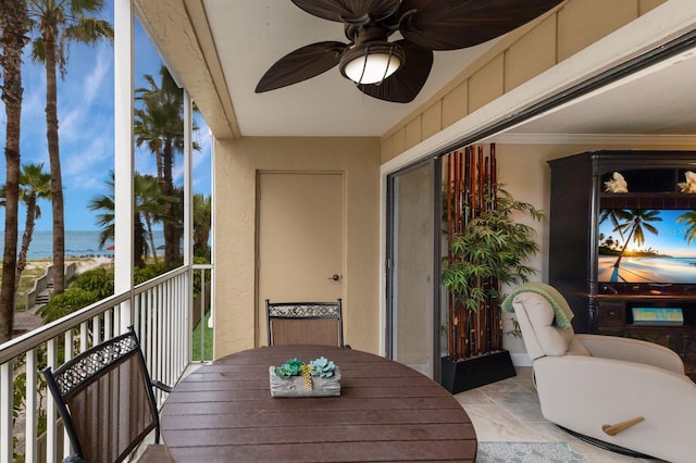 balcony with a water view and ceiling fan