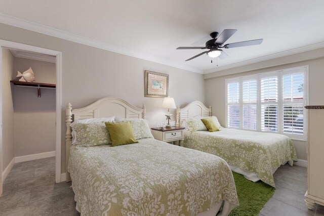 bedroom with a walk in closet, ornamental molding, ceiling fan, light tile patterned floors, and a closet