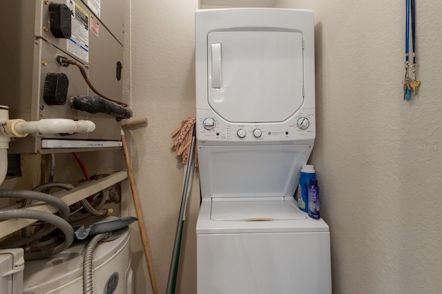 clothes washing area with stacked washing maching and dryer