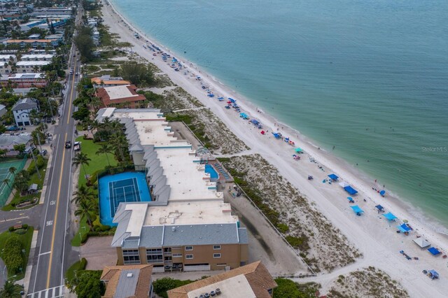 birds eye view of property with a water view and a beach view