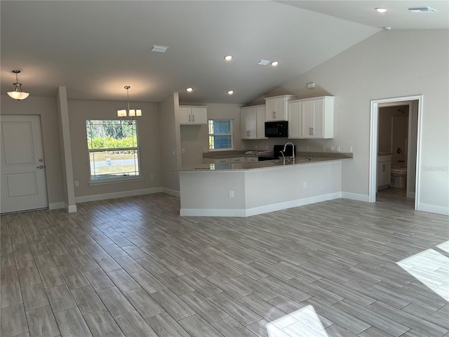 kitchen featuring black appliances, pendant lighting, white cabinetry, and kitchen peninsula