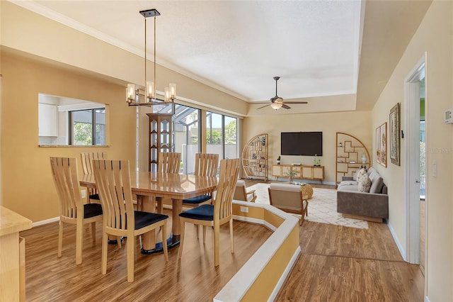 dining area featuring ceiling fan with notable chandelier, ornamental molding, a healthy amount of sunlight, and light wood-type flooring