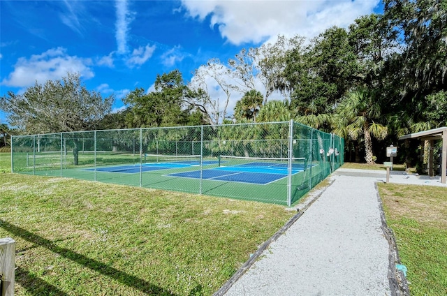 view of tennis court with a yard