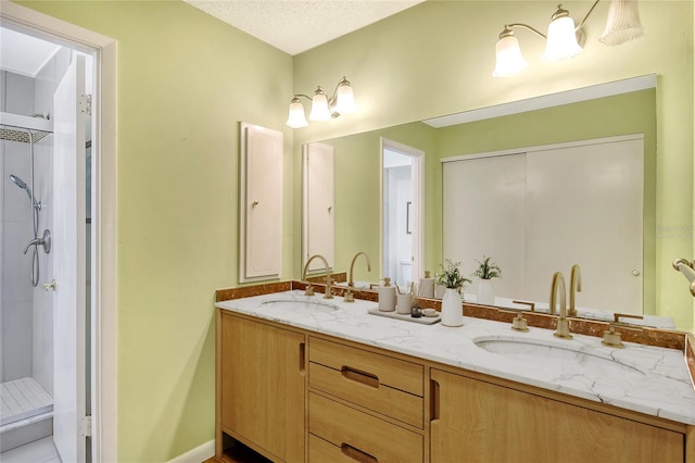 bathroom featuring walk in shower, vanity, and a textured ceiling