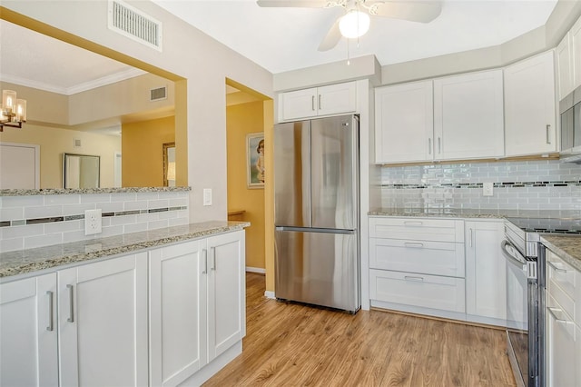 kitchen with stainless steel appliances, light stone countertops, light hardwood / wood-style floors, and white cabinets