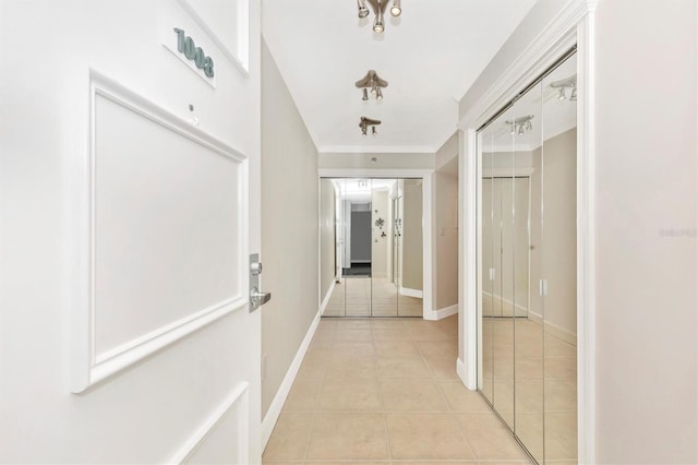 hall with light tile patterned flooring and ornamental molding