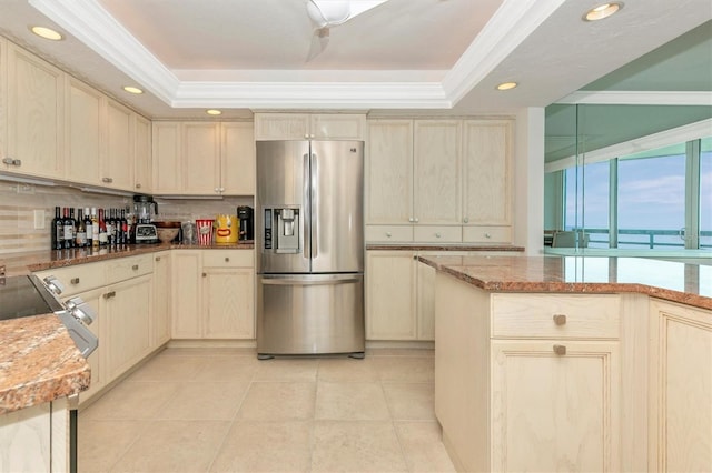 kitchen with light stone counters, a raised ceiling, and stainless steel fridge with ice dispenser