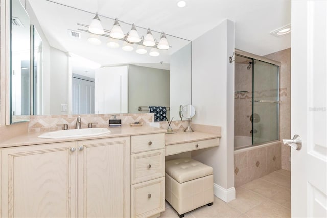 bathroom with decorative backsplash, enclosed tub / shower combo, tile patterned floors, and vanity