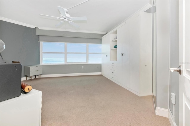 interior space featuring crown molding, light colored carpet, and ceiling fan