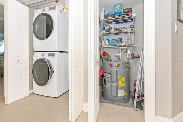 laundry room with stacked washer and dryer, electric water heater, and light tile patterned floors