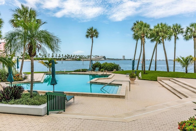 view of swimming pool with a water view and a patio