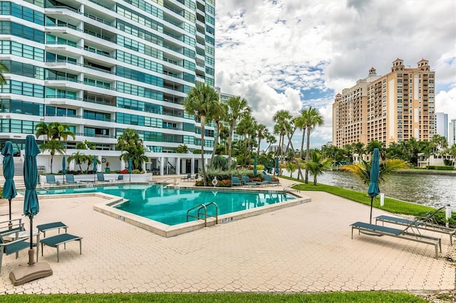 view of swimming pool with a water view and a patio area