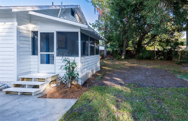 view of property exterior with a sunroom