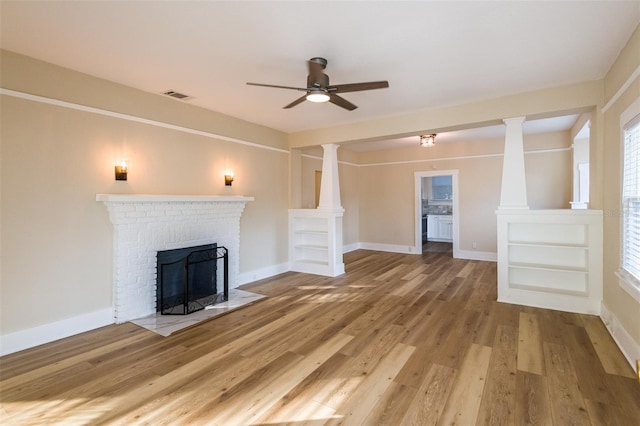 unfurnished living room with hardwood / wood-style floors, ceiling fan, and a brick fireplace