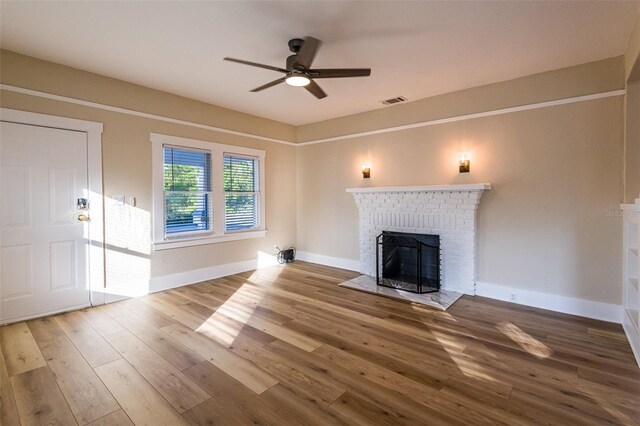 unfurnished living room featuring a fireplace, hardwood / wood-style flooring, and ceiling fan