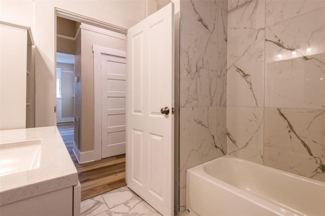 bathroom with vanity, wood-type flooring, and tiled shower / bath combo