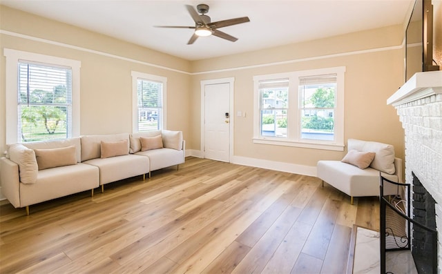 living area featuring a fireplace, light hardwood / wood-style floors, and plenty of natural light