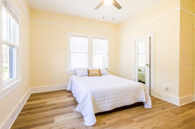 bedroom with light wood-type flooring, multiple windows, and ceiling fan