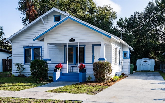 bungalow-style home featuring covered porch and a shed