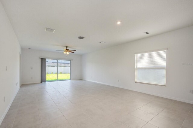 tiled spare room featuring ceiling fan