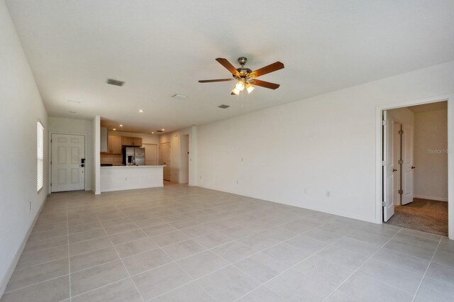 unfurnished living room featuring ceiling fan and light tile patterned flooring