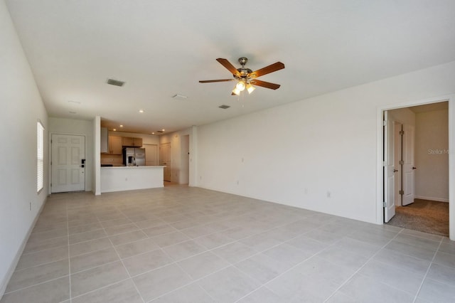 unfurnished living room featuring ceiling fan and light tile patterned floors