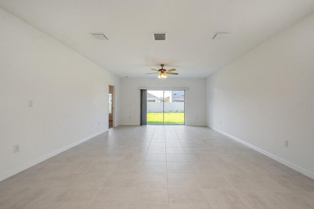 tiled spare room featuring ceiling fan