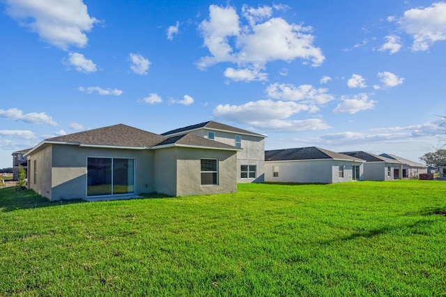 rear view of house featuring a yard